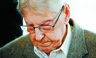 Regungslos und wortlos: Der ehemalige SS-Wachmann Reinhold Hanning schaut während des ersten Prozesstages auf den Boden. - dpa