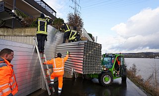 Feuerwehrleute bauen am Rheinufer bei Koblenz eine mobile Hochwasserschutzmauer auf. - picture alliance/dpa