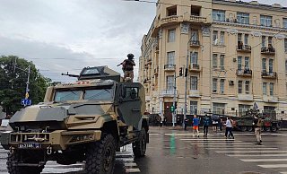 Ein Kämpfer steht auf einem gepanzerten Fahrzeug und bewacht einen Bereich in einer Straße in Rostow am Don. - -/AP/dpa