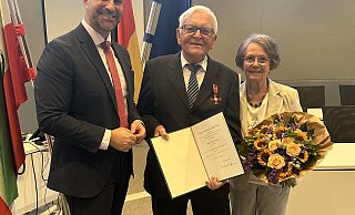 Landrat Ali Dogan überreichte Günter Seidel den Verdienstorden. Blumen erhielt Seidels Frau Heidi, die ebenfalls seit Jahrzehnten ehrenamtlich für den TuSpo Rahden aktiv ist. - Kreis Minden-Lübbecke