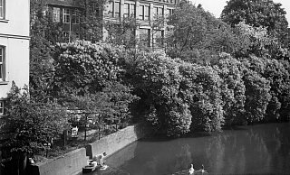 Vergangen: Die Aa zu früheren Zeiten mit den Waschfrauen im Vorder- und der Pelzfabrik im Hintergrund. - Kommunalarchiv