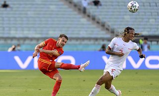 Der Schweizer Kevin Mbabu (r) blockt eine Flanke des Walisers Aaron Ramse. - Jean-Christophe Bott/Keystone/dpa