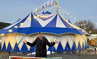 Williams Köllner mit einem Plakat vor dem Zelt: Für einen Winterzirkus muss so früh wie möglich plakatiert werden. - Ralf T. Mischer