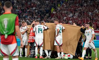 Die ungarischen Spieler halten einen Sichtschutz, während Stürmer Barnabas Varga behandelt wird. - Antonio Calanni/AP