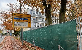 Ein blickdichter Bauzaun mit grünem Sichtschutz umgibt große Teile des Grundstücks vom Gütersloher Amtsgericht. Hier beginnen in Kürze die Bauarbeiten für einen Erweiterungsbau. - Christian Bröder