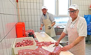 Fleischermeister Hans-Dieter Rottmann (rechts) und sein Mitarbeiter Heiko Weiße bereiten Fleisch für die Weiterverarbeitung zu Kasseler vor. - Frank-Michael Kiel-Steinkamp