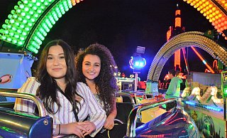 Startklar: Eda Yildiz und Rita Ghukasyan gehen in die Luft. Ihr Fluggerät wird sie gleich auf der Kirmes unterm bunten Lichterbogen in die Höhe befördern. - Karin Prignitz