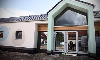 Der Haupteingang zur neuen Kita ist bewusst asymmetrisch gestaltet. Die farbigen Kreise an der Fassade sollen einen Fokus auf Bewegung symbolisieren. Von außen wirkt das Gebäude schon nahezu bezugsfertig. - Felix Eisele