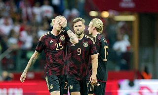Deutschlands (l-r) Marius Wolf, Niclas Füllkrug und Julian Brandt stehen nach dem Spiel auf dem Platz. - Christian Charisius/dpa