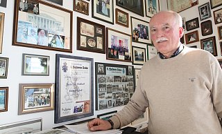 Bukes scheidender Ortsheimatpfleger Udo Waldhoff in seinem Arbeitszimmer, in dem die Wand mit vielen Erinnerungsfotos gespickt ist. - Uwe Müller
