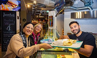 Omar Alkahlil ist optimistisch, dass sein "Yalla"-Stand im Harms-Markt laufen wird - und auch den trudelnden Harms-Markt mit anschieben kann. Vendy und Lena, v.l., freuen sich über frische Wraps. - Mike-Dennis Müller Omar Alkahlil ist optimistisch, dass sein "Yalla"-Stand im Harms-Markt laufen wird - und auch den trudelnden Harms-Markt mit anschieben kann. Vendy und Lena, v.l., freuen sich über frische Wraps. - Mike-Dennis Müller