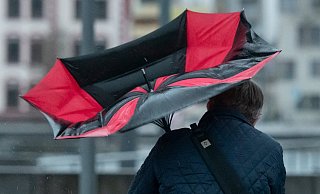  Der Regenschirm eines Spaziergängers ist am Dortmunder Phoenix-See wegen einer Windböe umgeklappt. Die Ausläufer des Orkantiefs „Victoria" zogen über Nordrhein-Westfalen hinweg. - picture alliance/dpa