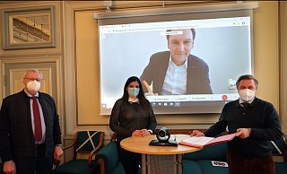 Der stellvertretende Bürgermeister Werner Seeger, Wirtschaftsförderin Lisa Kunert, Bürgermeister Tim Kähler und auf dem Bildschirm Glasfaser-Nordwest-Geschäftsführer Christoph Meurer bei der simultanen Vertragsunterzeichnung. - Frank-Michael Kiel-Steinkamp