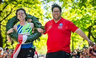 Schon beim Zieleinlauf fließen bei Florian Bochert die Tränen. Orgateam-Leiter Daniel Skakavac freut sich, seinem Vereinskollegen den Kranz überwerfen zu dürfen. - Sarah Jonek