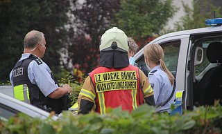 Polizisten und ein Feuerwehrmann sprechen gemeinsam mit der Psychologin, die in Kontakt mit dem Mann stand. - Florian Weyand
