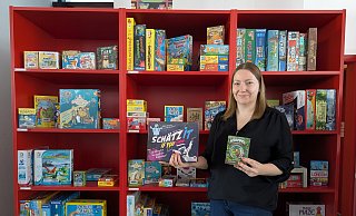 Corinna Grundmann präsentiert vor dem prall gefüllten Spieleregal der Stadtbücherei einige ihrer Empfehlungen für jung und alt. - Alex Wall