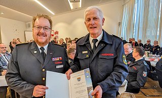 Kreisbrandmeister Stefan Nostitz übergibt dem ehemaligen Kreisbrandmeister Rudolf Lüke die Urkunde als Kreisehrenvorsitzender. - Burkhard Battran