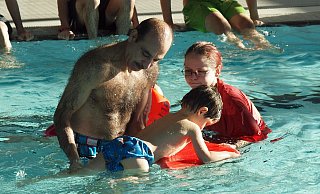 Vorbildlich: Liebevoll kümmert sich Christina Galsterer um den kleinen Sohn der syrischen Familie und bezieht den besorgten Vater in das Schwimmtraining mit ein. - Josef Köhne