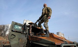 Ein ukrainischer Soldat steht nach einem Gefecht auf einem zerstörten russischen Schützenpanzer. - Foto: Efrem Lukatsky/AP/dpa