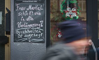 «Frau Merkel schickt uns in die Verlängerung! Durchhalten ist angesagt!» steht auf einer Tafel neben einem geschlossenen Geschäft im hessischen Friedberg. - Foto: Frank Rumpenhorst/dpa