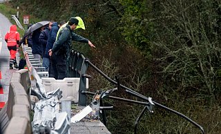Ein Zivilgardist zeigt auf den Bus, der in der Nähe von Pontevedra im Nordwesten Spaniens in die Tiefe gestürzt ist. - Cesar Arxina/Europa Press/AP/dpa