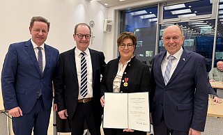 Landrat Christoph Rüther (r.) zeichnet Claudia Flottmeier mit der Bundesverdienstmedaille aus. Es gratulieren Salzkottens Bürgermeister Ulrich Berger (l.) und Ehemann Heinz Flottmeier. - Kreis Paderborn