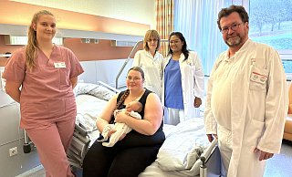 Jostein macht im St.-Ansgar-Krankenhaus der KHWE die 1000 voll: (von links) Sofie Heising (Hebamme), Jacqueline Glormann mit Jostein, Anette Schürzenberg (Pflegefachkraft Wochenbettstation), Veantha Marimuthu (Assistenzärztin) und Dr. Henning Grastorf (Chefarzt). - KHWE