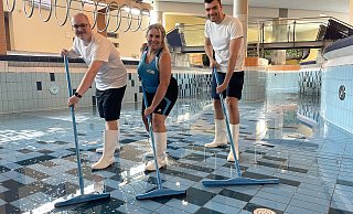 Die BBF-Mitarbeitenden Liam Rennekamp, Cynthia Naggatis und Henrique Merlim Lotz (v.l.) reinigen den Strömungskanal im Freizeitbereich des Ishara. - Stadtwerke Bielefeld GmbH