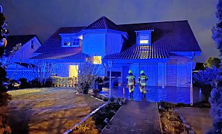 Feuerwehrleute vor der ehemaligen Pizzeria in Sennelager, auf deren Balkon es gebrannt hat. - Ralph Meyer