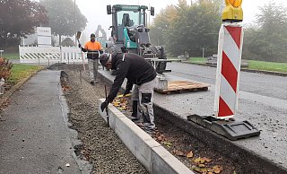 Mitarbeiter der Warburger Tiefbaufirma Nolte setzen im unteren Teil der Anton-Böhlen-Straße bereits die Bordsteine. - Dieter Scholz