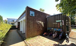 Hinter einer großen Hecke verschwindet der Kindergarten Löwenzahn, dessen Gebäude aus dem Jahr 1967 stammt und für die Betreuung kleinerer Kinder gar nicht geeignet ist. - Nicole Sielermann