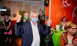 Die Fäuste hoch reckt Grünen-Bürgermeisterkandidat Klaus Schröder bei der Bekanntgabe der ersten Ergebnisse. Rechts hinter ihm am Tisch sitzt Landratskandidatin Norika Creuzmann. - BESIM MAZHIQI