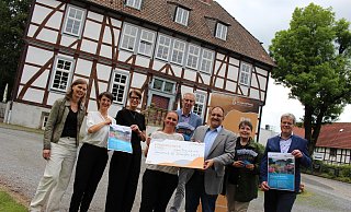 Annette Gemke (v.l.), Sylvia Daume und Andrée Dietsch vom Vokalensemble "Anis oder Mandel", Carolin Hupe von der Gemeinde Borchen, Jörg Wenzel, Schulleiter der Schule an der Altenau, Hugo Kremer von der Bürgerstiftung "Zukunft Borchen", sowie Nelo Thies, verantwortlich für Musical und Puppenspiel, und Bürgermeister Uwe Gockel präsentieren das neue Programm der Veranstaltungsreihe "Umsonst und draußen" rund um den Mallinckrodthof in Borchen. - Pauline Maus