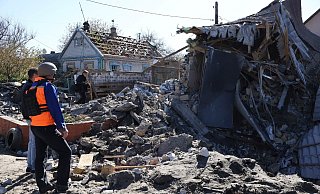 Menschen betrachten ein Gebäude in Saporischschja, dass nach ukrainischen Angaben durch russischen Beschuss zerstört wurde. - Andriyenko Andriy/AP/dpa