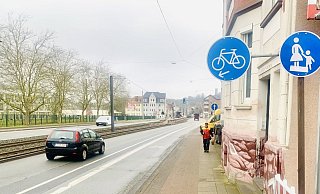 Stadteinwärts, in Höhe der Stichstraße Sandhagen, weist der Pfeil des Verkehrsschilds für die Radfahrer eher auf den alten Radweg, der sich immer noch durch in Rot vom grauen Teil des ehemaligen Fußwegteils abhebt. Der Bikelane-Streifen (links davon) hingegen ist auf diesem Abschitt grau. - Ivonne Michel Stadteinwärts, in Höhe der Stichstraße Sandhagen, weist der Pfeil des Verkehrsschilds für die Radfahrer eher auf den alten Radweg, der sich immer noch durch in Rot vom grauen Teil des ehemaligen Fußwegteils abhebt. Der Bikelane-Streifen (links davon) hingegen ist auf diesem Abschitt grau. - Ivonne Michel