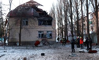 Rettungskräfte stehen neben einem beschädigten Gebäude in Kiew. - -/Ukrinform/dpa