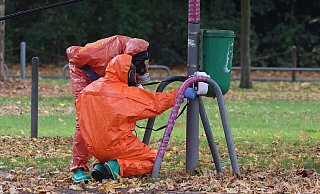 Feuerwehrleute überprüfen eine Mülltonne. - David Young/dpa