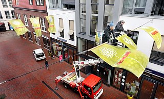 Verena Schrick und Kerstin Köhler (v.l., Die Schmücker) lassen die Banner zum "Gütersloher Frühling" in der Eickhoffstraße wehen. - Patrick Menzel