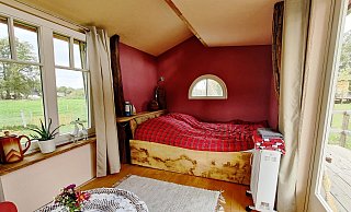 Das Bett ist gegenüber von der Sitzecke. - Lena Kley
