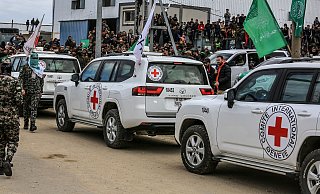 Autos des Internationalen Roten Kreuzes stehen im Februar 2025 bereit, während Kämpfer der Al-Kassam-Brigaden, des militärischen Flügels der islamistischen Terrororganisation Hamas, israelische Geiseln an Vertreter des Internationalen Komitees vom Roten Kreuz (IKRK) übergeben. Das abgemagerte und blasse Aussehen der Geiseln sorgte in Israel für Entsetzen. (zu dpa: «Hamas-Kreise: Geisel-Übergabe an drei Orten im Gazastreifen») Foto: Abed Rahim Khatib/dpa +++ dpa-Bildfunk +++ - Abed Rahim Khatib/dpa
