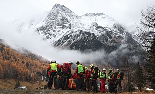 Bozen: Mitglieder der Bergrettung warten vor den verschneiten Bergen des Ortler Gebirges auf den Rettungshubschrauber. - Karl-Josef Hildenbrand/dpa