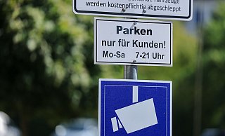 Ein Schild weist auf einem Supermarktparkplatz darauf hin, dass Parken nur für Kunden gestattet ist und der Platz videoüberwacht wird. - Jan Woitas/dpa