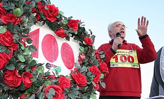 Rosen umranken herzförmig das Schild mit der Jubiläumszahl, neben dem Eckhard Grummert für den Tunnel wirbt. - Foto: Nicole Bliesener