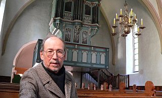 Organist Dr. Hinrich Paul vor der Orgel in der Marienkirche Wallenbrück. Mittlerweile ist das Orgelgehäuse abgebaut und untersucht worden. - Mareike Patock