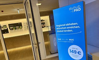Die blaue Werbetafel der neuen Airline steht im Aufgang zum Sitzungssal des Kreishauses in der Paderborner Aldegreverstraße. - Jens Reddeker