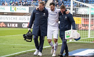 Darmstadts Stürmer Luca Pfeiffer hat sich am rechten Knöchel verletzt und muss von zwei Betreuern in die Kabine begleitet werden. - picture alliance/dpa