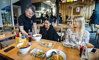 Jan Wu (v.l.) serviert Sanjuka Kesavarajan die Schüssel mit Ramen. Palina Küster schaut gespannt, was ihre Freundin bestellt hat. - Sarah Jonek