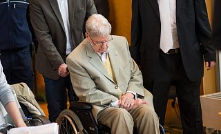 Der frühere Auschwitz-Wachmann Reinhold Hanning wurde zum dritten Verhandlunstag in einem Rollstuhl zu seinem Platz geschoben. - dpa