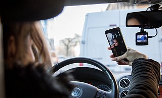 Gestellte Szene: Eine Frau macht während der Fahrt ein Selfie. - picture alliance / dpa Themendienst