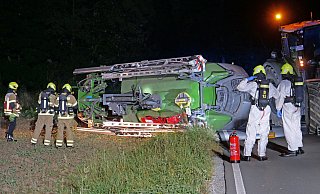 Einsatzkräfte der Feuerwehr Paderborn dichten in Wewer den Tank der umgekippten Feldspritze ab. - Ralph Meyer